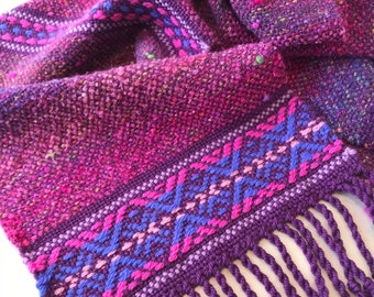 Handwoven scarf in pinks, purples and blue with decorative borders