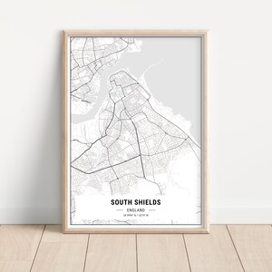 May include: A black and white map print of South Shields, England. The map shows the city's streets and coastline. The text "South Shields, England" and the coordinates "54.9994° N, 1.4274° W" are printed below the map.
