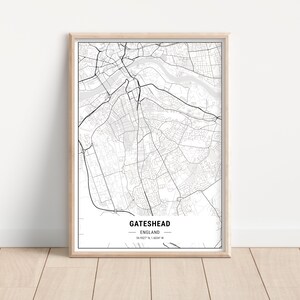 May include: A framed monochrome map print of Gateshead, England. The detailed map shows roads, buildings, and waterways. The print is in a light wood frame, with the text "Gateshead, England" at the bottom.