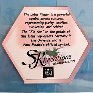 May include: A hexagonal card with text about the Lotus Flower and Zia Sun symbols. The card has a pink and white design with the text "SK Kreations Albuquerque, NM" and a "NM True Certified" logo.