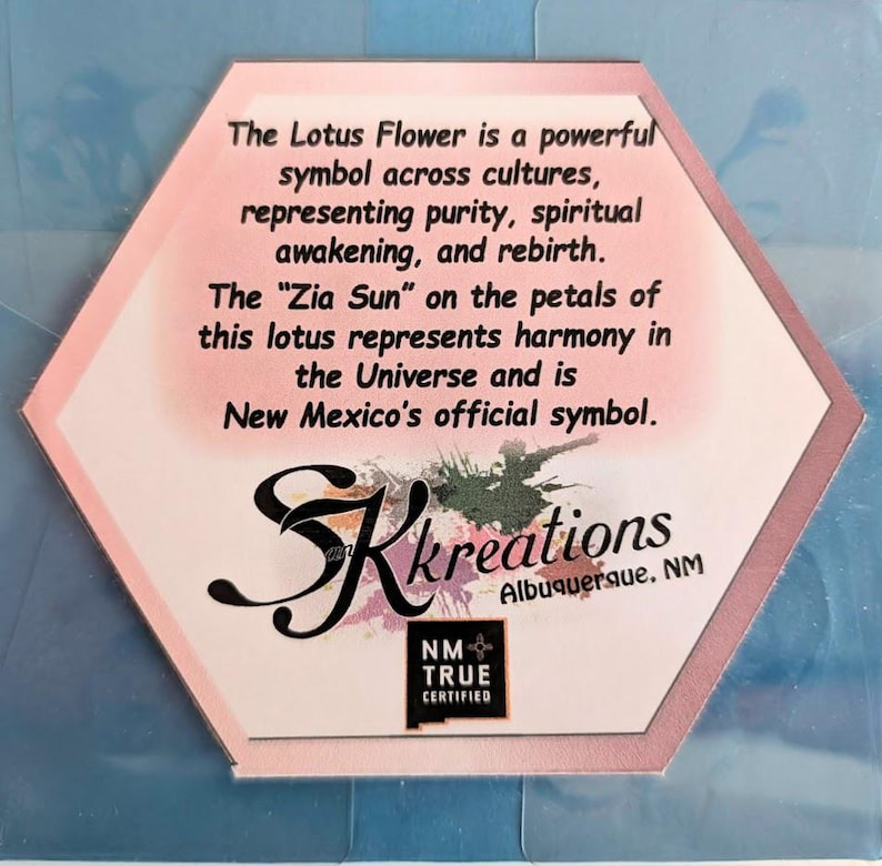 May include: A hexagonal card with text about the Lotus Flower and Zia Sun symbols. The card has a pink and white design with the text "SK Kreations Albuquerque, NM" and a "NM True Certified" logo.