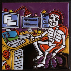 May include: A colorful ceramic tile depicting a skeleton sitting at a computer desk. The skeleton is wearing headphones and has a red and orange chair. The desk has a computer monitor, a laptop, and a lamp. The tile has a purple background and is decorated with colorful details.