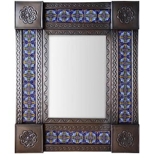 May include: A rectangular mirror with a decorative frame. The frame is made of dark metal with embossed floral corner accents and a border of blue, yellow, and white patterned tiles. The mirror's frame has a scalloped edge.
