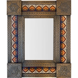 Puede incluir: Espejo rectangular con marco decorativo. El marco es de metal oscuro y texturizado y presenta intrincados azulejos en tonos naranja, azul y crema. Las esquinas tienen detalles cuadrados con motivos florales.