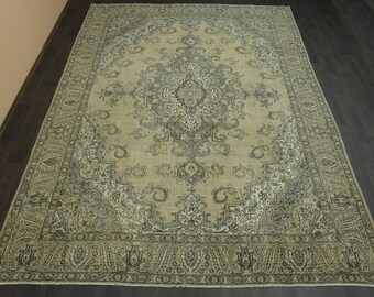 Puede incluir: Una alfombra vintage con fondo beige y intrincados patrones florales en blanco y negro. La alfombra tiene un aspecto descolorido y una textura desgastada.