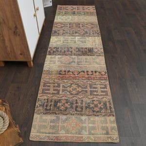 May include: A long, narrow rug with a colourful geometric pattern in shades of brown, beige, orange, and blue. The rug has a distressed, vintage look and is perfect for adding a touch of bohemian style to any room.