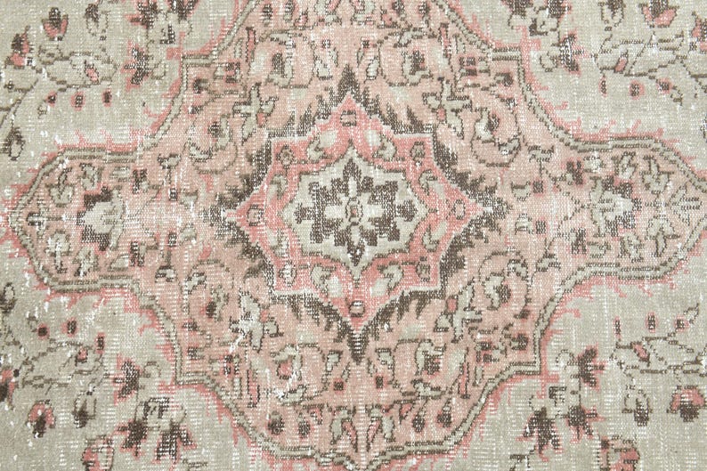 Puede incluir: Una alfombra vintage con un esquema de color rosa y beige descolorido. La alfombra presenta un medall&oacute;n central con intrincados patrones florales y un dise&ntilde;o geom&eacute;trico repetitivo.