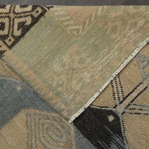 May include: Close-up of a multi-coloured woven rug with a geometric pattern. The rug has a fringed border and is made of natural fibres.