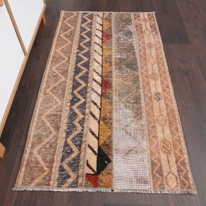 May include: A vintage style rug with a geometric pattern in shades of brown, beige, and black. The rug has a distressed look and is made of woven fibres.