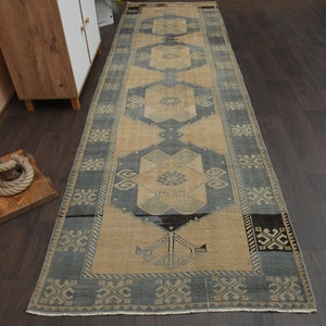May include: A vintage style runner rug with a blue and beige colour scheme. The rug has a geometric pattern with a central medallion.