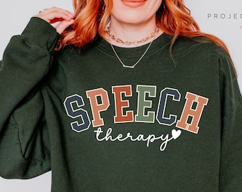 May include: Forest green sweatshirt with the text "SPEECH therapy" in colorful block letters with a small white heart.