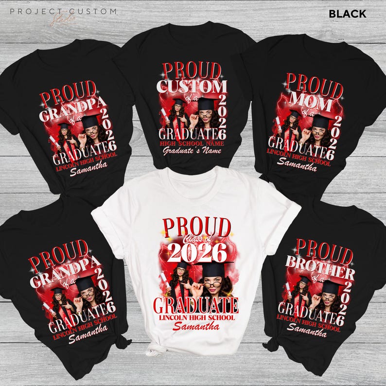 May include: A collection of black and white graduation t-shirts. Each shirt has a red and white design with the words "Proud Grandpa," "Proud Mom," "Proud Brother," and "Proud Graduate." A white shirt says "Proud Class of 2026."