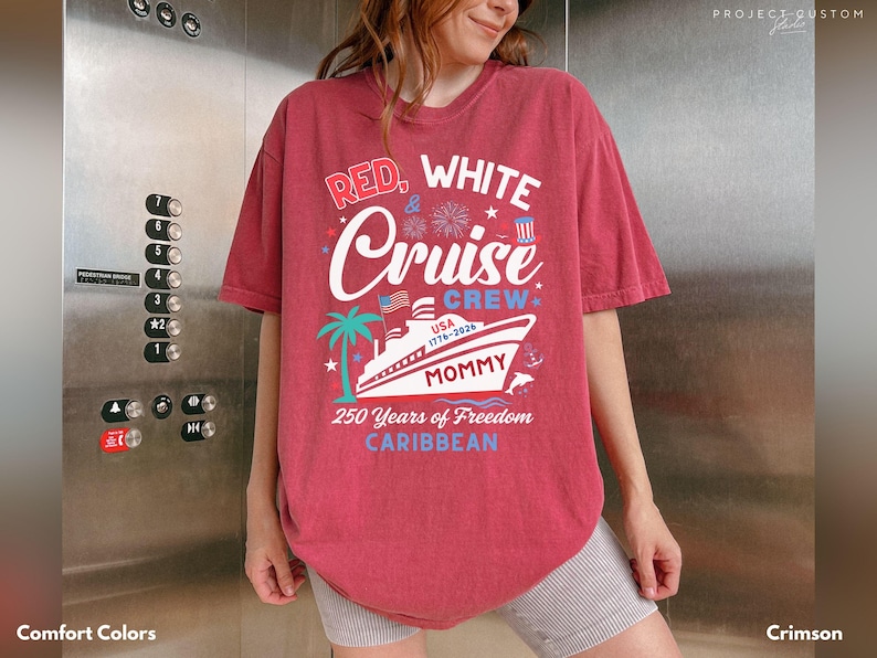 Puede incluir: Camiseta de color carmes&iacute; con el texto "Red, White & Cruise Crew" y un gr&aacute;fico de un crucero, palmeras y fuegos artificiales. La camiseta tambi&eacute;n incluye el texto "250 Years of Freedom Caribbean."