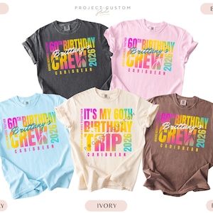 May include: Five short-sleeved t-shirts in various colors: charcoal, light pink, light blue, ivory, and brown. Each shirt features a colorful graphic that reads "60th Birthday Brittany's Crew Caribbean 2026."