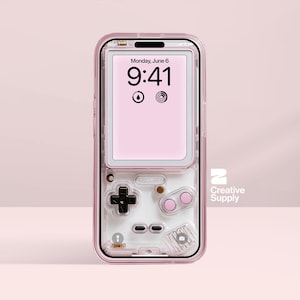 May include: A clear pink phone case with a retro video game design. The case has a D-pad, buttons, and a screen showing the time and date. The Creative Supply logo is visible on the right.