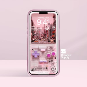 May include: A transparent phone case featuring a retro video game controller design in pink and purple hues. The phone screen shows a city scene with the time 9:41 AM. The Creative Supply logo is visible.