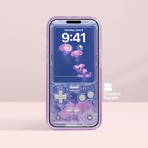Puede incluir: Una funda de teléfono transparente y lila con un diseño de mando de videojuego retro. La pantalla del teléfono muestra un fondo de pantalla de medusas y la fecha, lunes 6 de junio, 9:41. El logotipo de Creative Supply es visible.