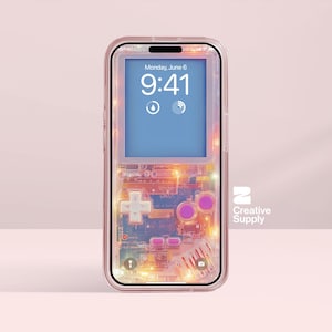 May include: Transparent phone case with a retro video game design. The case shows a screen displaying the date and time, with a cross-shaped directional pad and pink buttons. The case has a clear border and the text "Creative Supply".