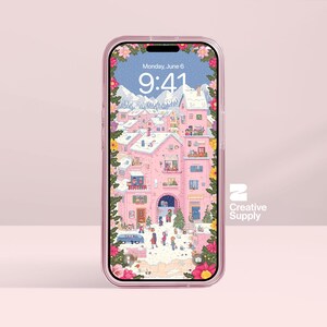 Puede incluir: Una funda transparente para teléfono con borde rosa encierra un smartphone que muestra una ilustración caprichosa de un pueblo rosa con montañas nevadas. La pantalla muestra la fecha, lunes 6 de junio, y la hora, 9:41.