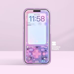 May include: A transparent phone case with a retro video game design. The case has a pink and purple colour scheme with a cross-shaped directional pad and other game buttons. The phone screen displays the time and date. The Creative Supply logo is visible.