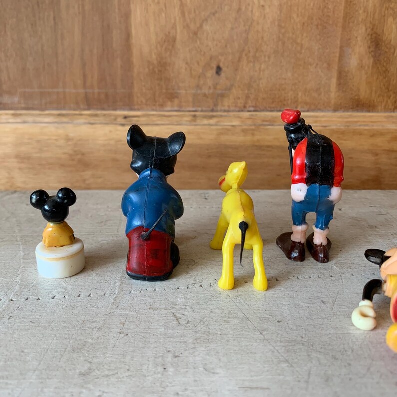Puede incluir: Una colecci&oacute;n de cuatro figuritas de pl&aacute;stico vintage. Las figuritas son de Mickey Mouse, Pluto, Goofy y un rat&oacute;n gen&eacute;rico. Las figuritas est&aacute;n todas en diferentes poses y est&aacute;n pintadas en colores brillantes.