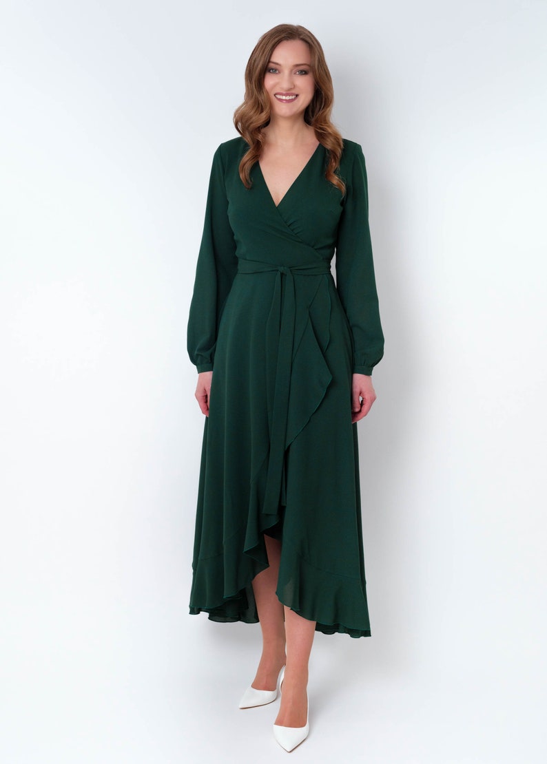 May include: A long-sleeved, emerald green wrap dress with a ruffled hem and a tie at the waist.