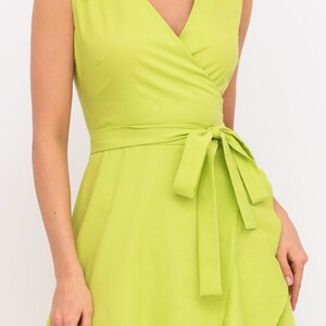 May include: A lime green wrap dress with a V-neckline and a tie at the waist. The dress has a ruffled hem.