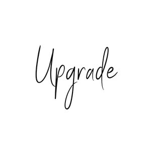 Op de afbeelding: Handgeschreven kalligrafie in zwarte inkt die "Upgrade" zegt.