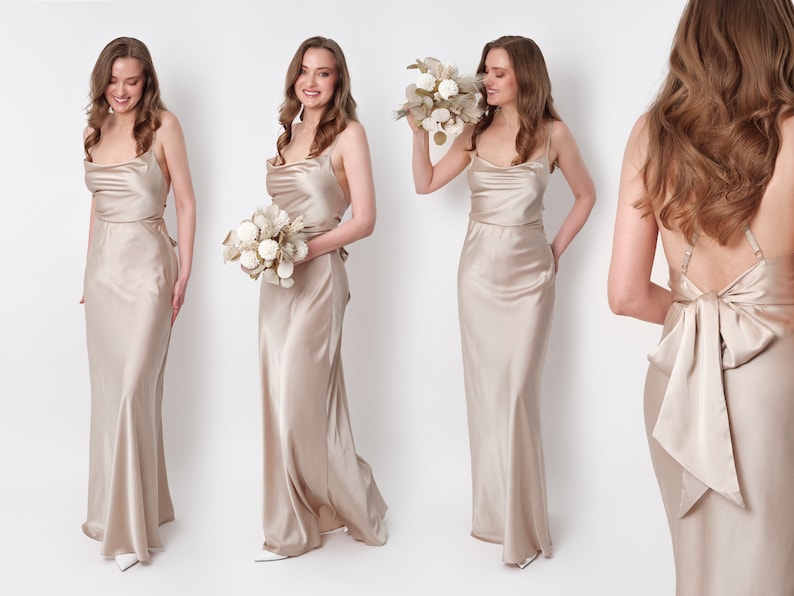 May include: Three women wearing long, champagne-colored satin dresses. The dresses have a cowl neckline and a fitted bodice. The dress on the right has a large bow in the back. The women are holding bouquets of dried flowers.