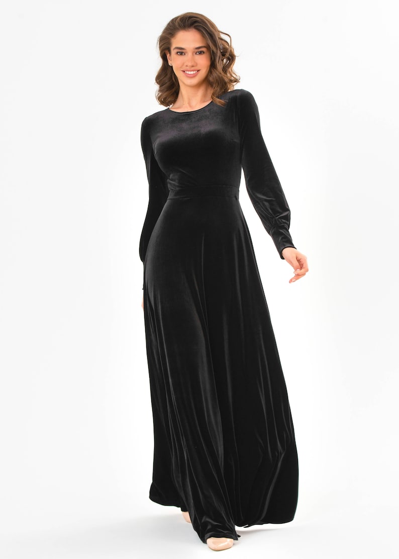 May include: A long-sleeved black velvet dress with a round neckline and a flowing skirt.