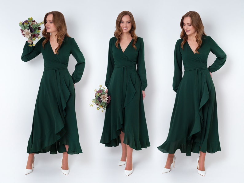 May include: Three women wearing long-sleeved, emerald green wrap dresses with ruffled hems. The dresses have a V-neckline and a tie at the waist. The women are holding bouquets of flowers.