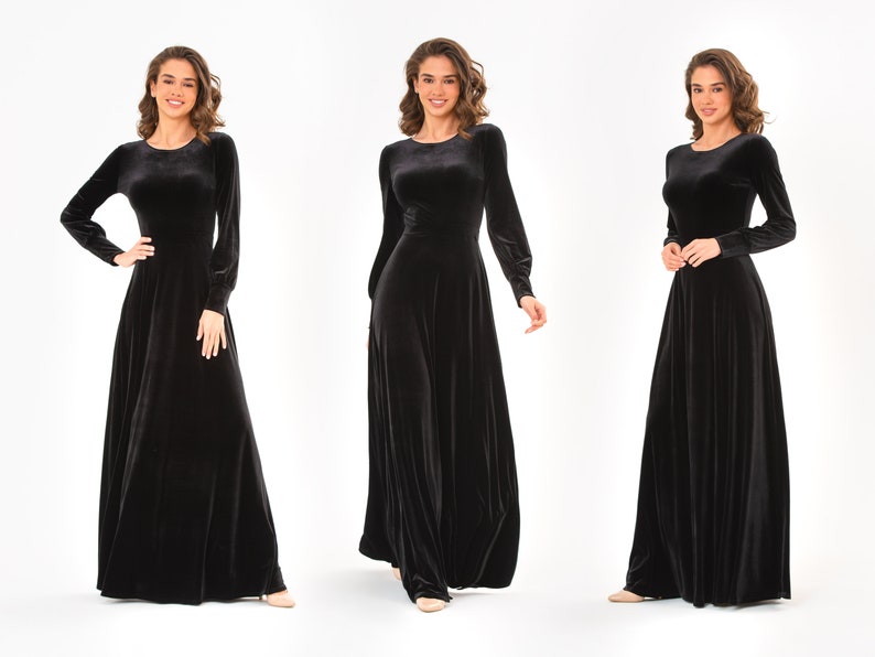 May include: Three women wearing long-sleeved black velvet dresses with a round neckline. The dresses have a flowing, A-line silhouette.