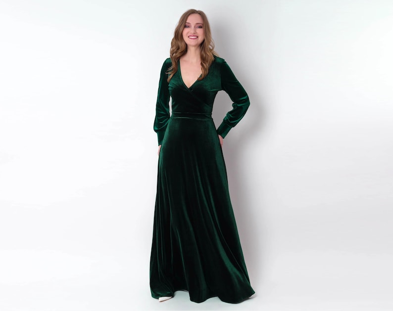 K&ouml;nnte beinhalten: Ein lang&auml;rmeliges, smaragdgr&uuml;nes Samtkleid mit V-Ausschnitt und Wickel-Oberteil.