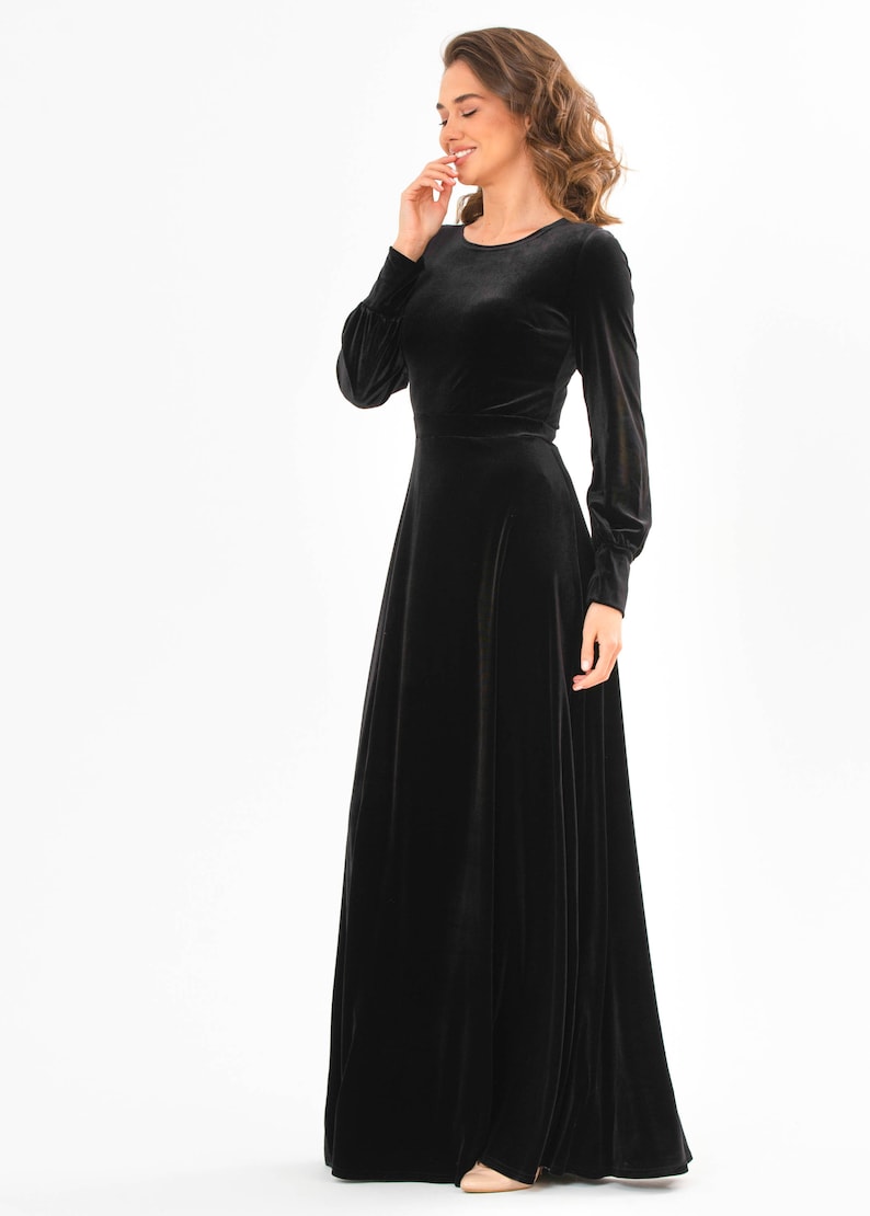 May include: A black velvet maxi dress with long sleeves and a round neckline.