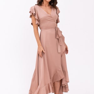 May include: A mauve wrap dress with a ruffled hem and short sleeves. The dress has a V-neckline and a tie at the waist.