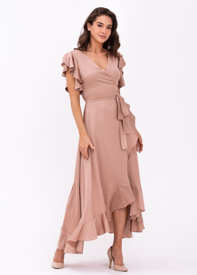 May include: A mauve wrap dress with a ruffled hem and short sleeves. The dress has a V-neckline and a tie at the waist.