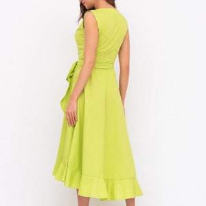May include: A lime green midi dress with a ruffled hem and a tie at the waist.