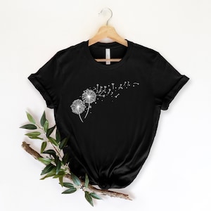 May include: Black t-shirt with a white graphic of two dandelions with seeds blowing in the wind.