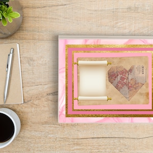 May include: A pink and gold journal with a heart-shaped map and a scroll on the cover. The journal has a pink and gold marble design.