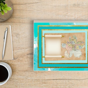 May include: A teal blue and gold notebook with a scroll and a map in the shape of a flower. The scroll is blank and the map is of the world.