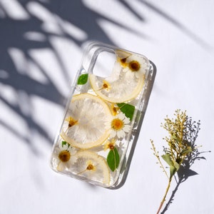 Puede incluir: Una funda transparente para tel&eacute;fono con flores secas y rodajas de lim&oacute;n prensadas en su interior. La funda est&aacute; dise&ntilde;ada para un tel&eacute;fono inteligente con un recorte para el objetivo de la c&aacute;mara.