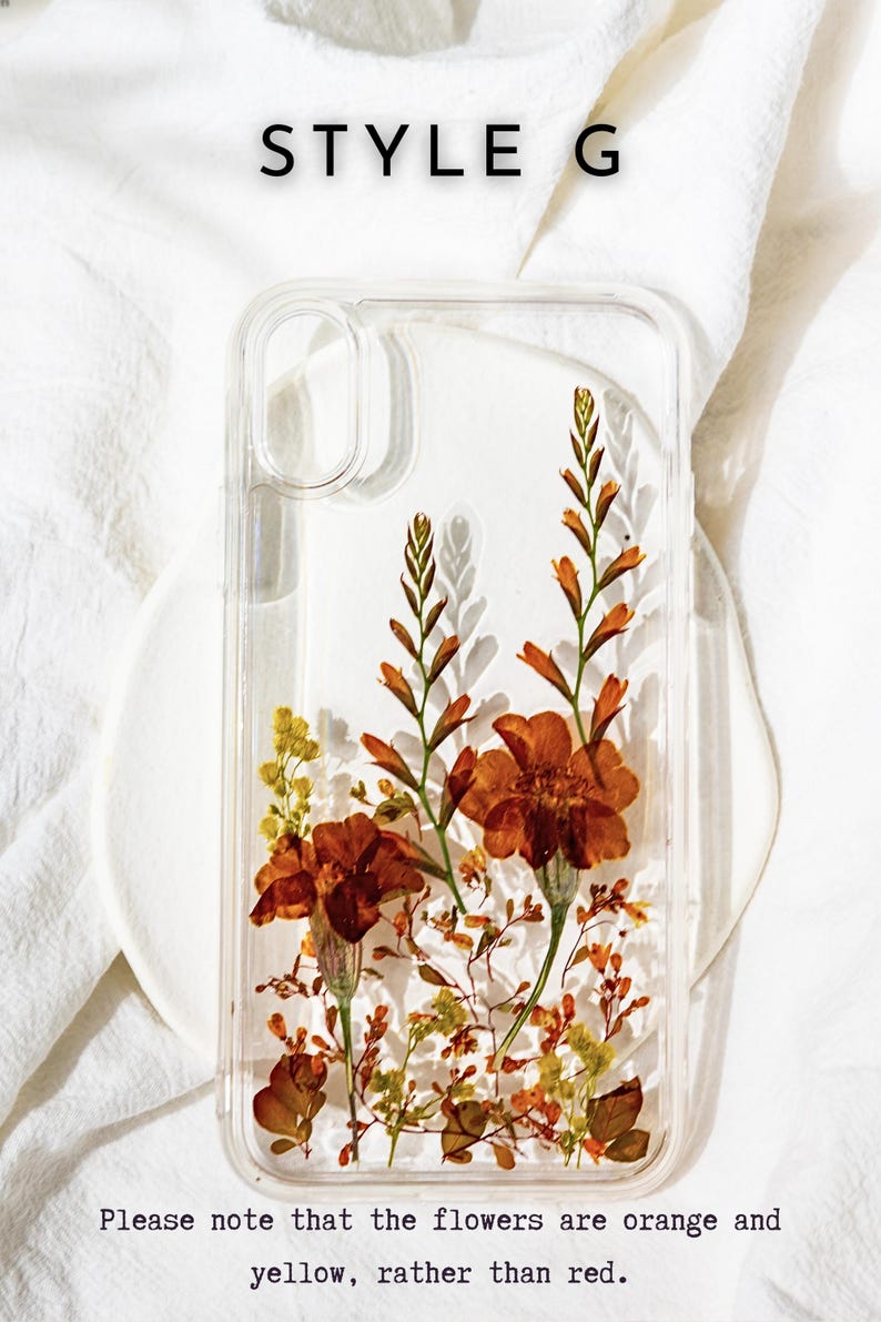May include: A clear phone case with pressed orange and yellow flowers inside. The case is on a white surface. "STYLE G" is written above the case.
