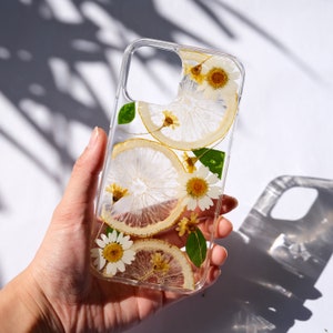 Puede incluir: Una funda transparente para tel&eacute;fono con flores secas y rodajas de lim&oacute;n prensadas en su interior. La funda est&aacute; dise&ntilde;ada para un tel&eacute;fono inteligente con una protuberancia de c&aacute;mara.