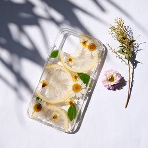 Puede incluir: Una funda transparente para tel&eacute;fono con flores secas y rodajas de lim&oacute;n prensadas en su interior. La funda est&aacute; dise&ntilde;ada para un tel&eacute;fono inteligente con un recorte para la c&aacute;mara.