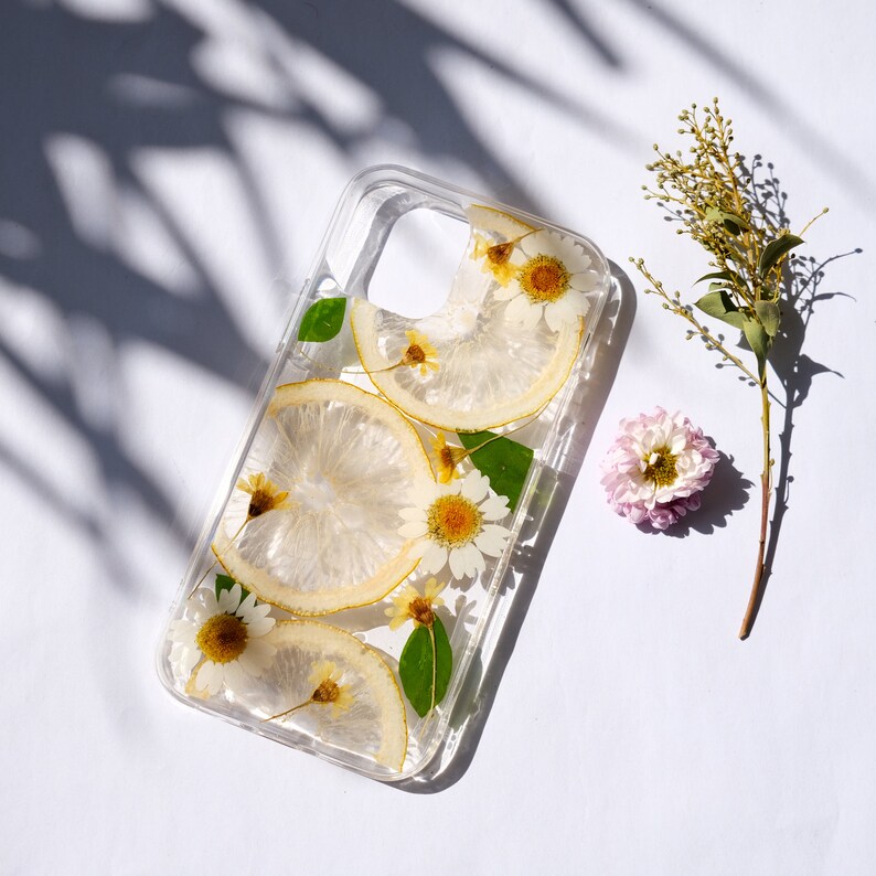 Puede incluir: Una funda transparente para tel&eacute;fono con flores secas y rodajas de lim&oacute;n prensadas en su interior. La funda est&aacute; dise&ntilde;ada para un tel&eacute;fono inteligente con un recorte para la c&aacute;mara.
