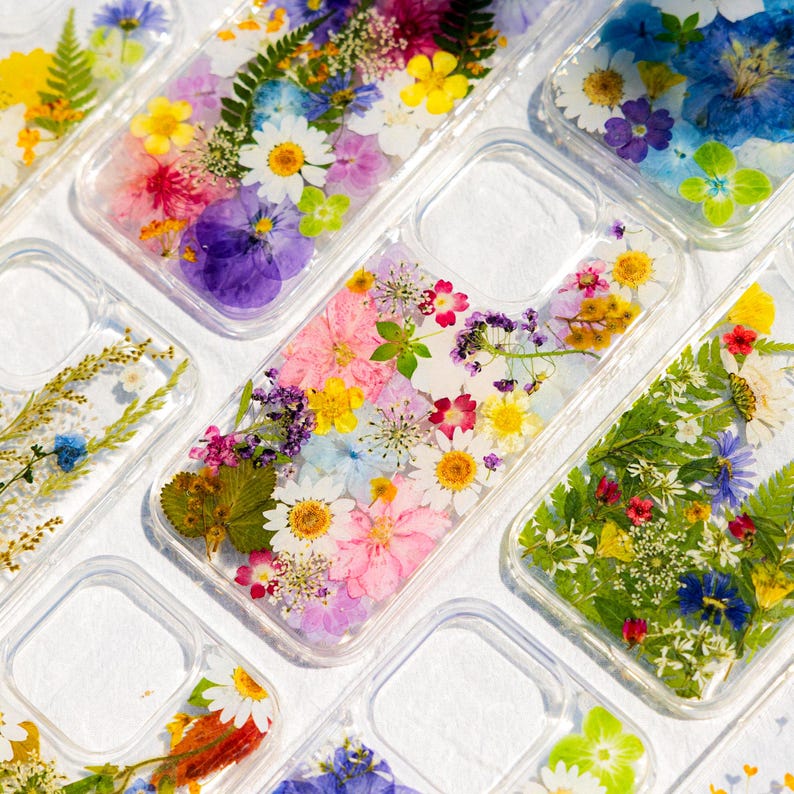Elevate your phone's style with our handcrafted Real Pressed Flower Phone Cases. Designed to fit seamlessly with iPhone 16, 15, 14, 13, 12, 11 Pro Max, XR, X, 8 SE, Samsung Galaxy S23 Ultra, and Google Pixel 8 Pro, these cases are more than just accessories—they're a celebration of nature's beauty. Each case is meticulously arranged with real pressed flowers, offering not only stunning aesthetics but also premium protection for your device.