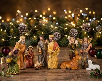 May include: A Nativity scene set with figures of the Holy Family, the Three Wise Men, an angel, a shepherd, and animals. The figures are in various colors, including gold, red, and green, set on a wooden surface with Christmas lights in the background.