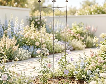 Op de afbeelding: Een verweerde metalen tuinrek met een rechthoekig frame en decoratief krulwerk. Het rek is versierd met klimrozen en andere bloeiende planten. De bovenkant van het rek heeft drie decoratieve toppen. De tuinsetting heeft een verscheidenheid aan kleurrijke bloemen.