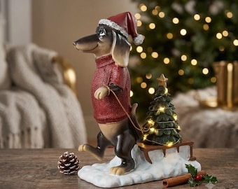 La magia del Natale a quattro zampe: un bassotto con la slitta dell'albero di Natale.