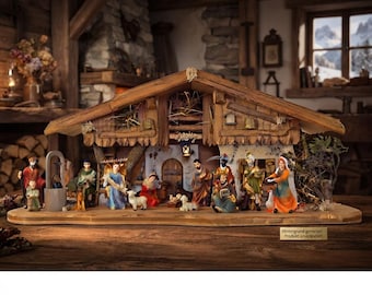 May include: A wooden nativity scene set featuring hand-painted figurines of people and animals arranged under a rustic barn structure. The display includes a central stable with hay, a small lantern, and various figures including an angel and sheep.